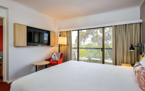 Bed with TV and balcony beside it