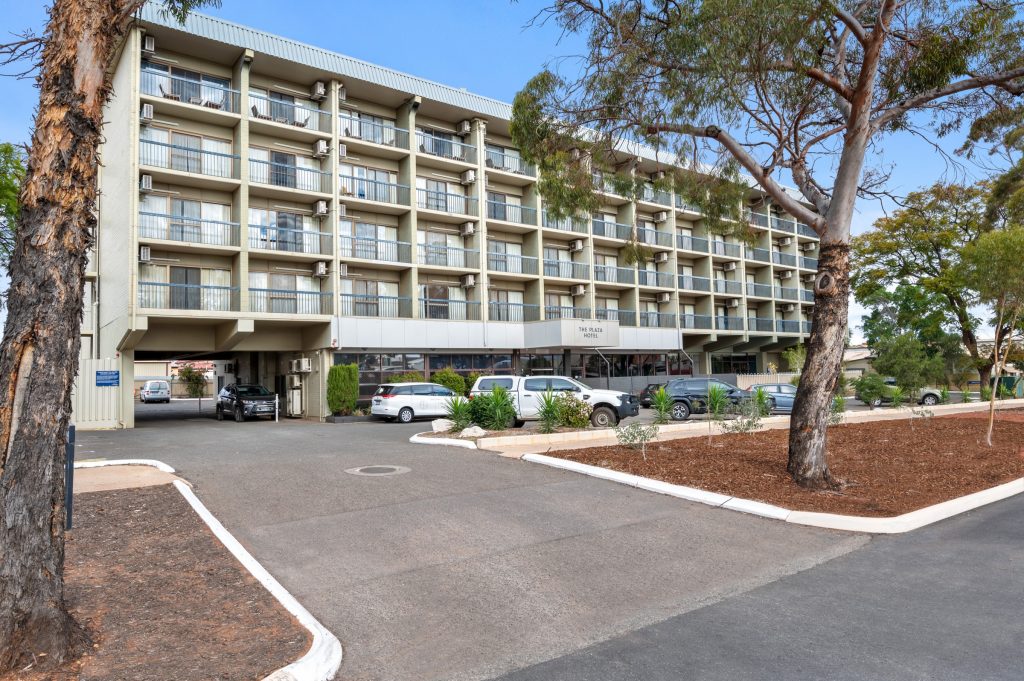 The front entryway to the Plaza Hotel Kalgoorlie, showing apartments with balconies and ample parking